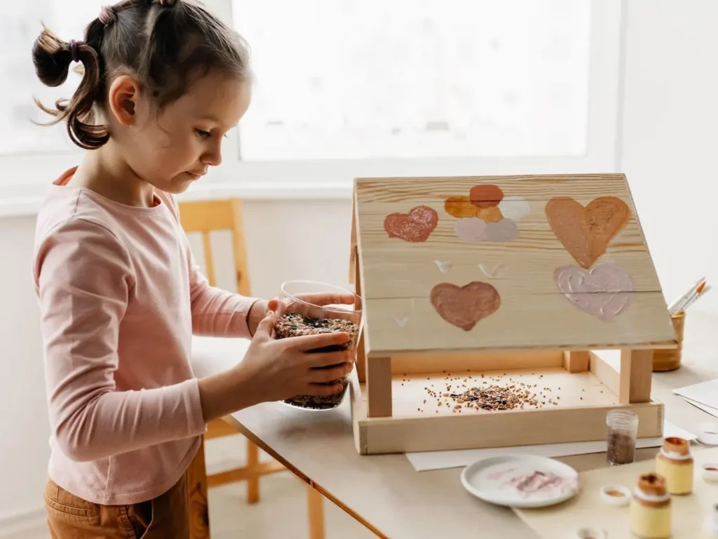 Дівчинка й годівничка з дерева